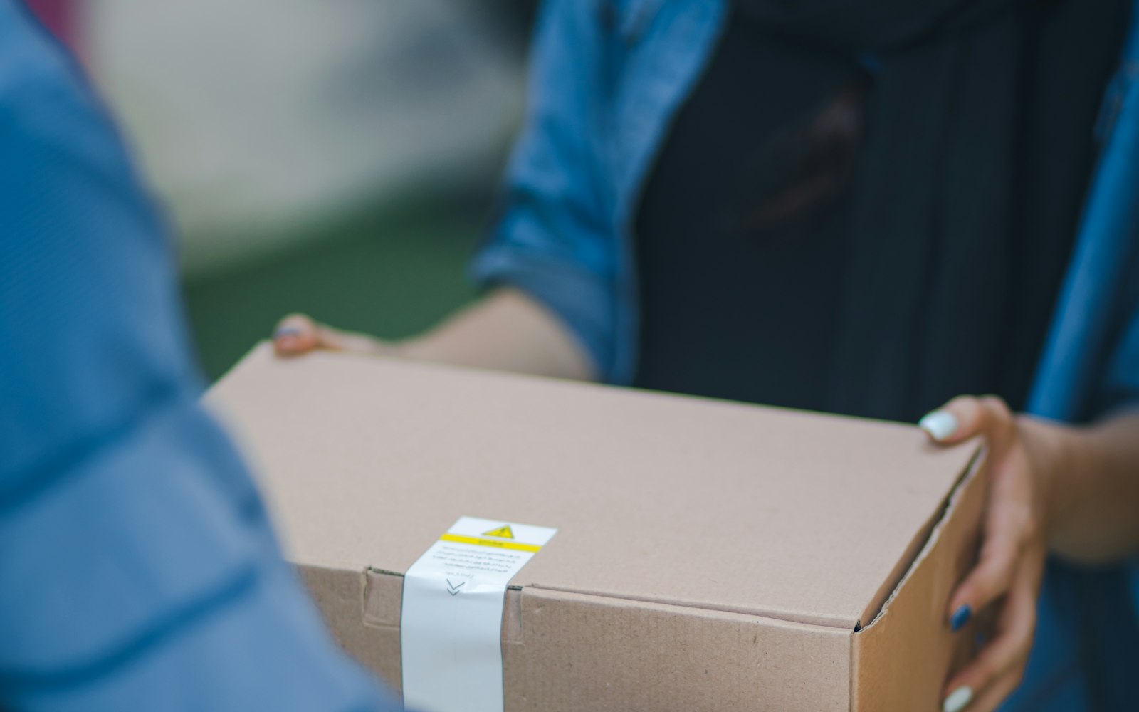 A carton being handed from one person to another